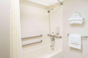 a bathroom with a shower and a white tub at Super 8 by Wyndham Branson/Andy Williams Theatre in Branson