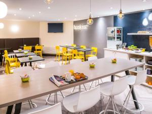 une salle à manger avec des tables et des chaises jaunes dans l'établissement ibis Styles Paris 15 Lecourbe, à Paris