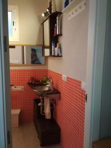 baño con lavabo y pared de azulejos rojos en Apartamento Privado en Alameda de Hércules, en Sevilla
