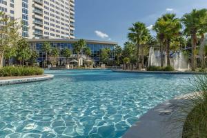 uma piscina com palmeiras e edifícios em Hyatt Regency Orlando em Orlando