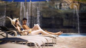 a man and woman sitting in chairs near a fountain at Hyatt Regency Orlando in Orlando