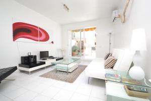 ein Wohnzimmer mit einem weißen Sofa und einem Glastisch in der Unterkunft Viva Sitges - Mayo Terrace in Sitges