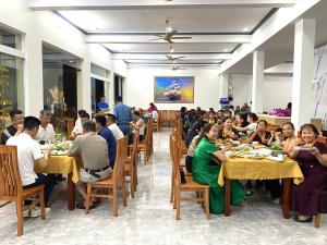 a group of people sitting at tables in a restaurant at An Thảo Ba Bể Hotel in Ba Be
