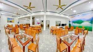 un salón de banquetes con mesas y sillas de madera en An Thảo Ba Bể Hotel, en Ba Be18