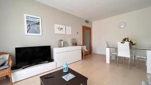 a living room with a television and a table at APARTAMENTO LOS GIRASOLES 1 in Salou