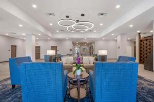 a waiting room with blue chairs and a couch at Pestana Orlando Suites - Lake Buena Vista in Orlando