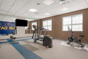 a gym with exercise bikes and a flat screen tv at Pestana Orlando Suites - Lake Buena Vista in Orlando