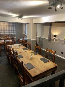 une salle à manger avec une grande table et des chaises en bois dans l'établissement The White Swan Hotel, à Duns