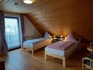 een slaapkamer met 2 bedden in een houten kamer bij Ferienwohnungen Aemy in Ostseebad Sellin