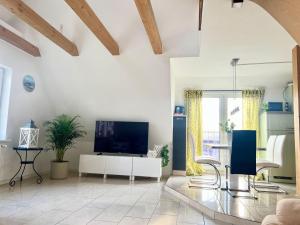 a living room with a flat screen tv and a couch at Seeadler-Wohnung in Diedrichshagen