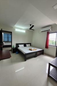 1 dormitorio con 1 cama y ventilador de techo en Hotel Harigardenia - Airport Mattuthavani ring road, Near Meenakshi Mission Hospital, Madurai, en Tallākulam