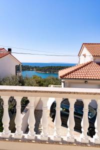 a white balcony with a view of the water at Grubelic House in Rab