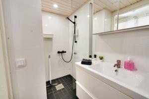 a white bathroom with a sink and a shower at Upea yksiö+parveke. Ihastu, parhaalla paikalla. in Tampere