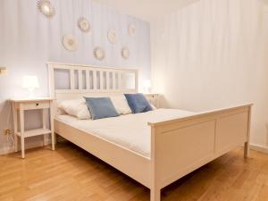 uma cama branca com almofadas azuis num quarto em Apartment Dingworthstraße em Hildesheim