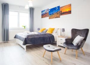 a bedroom with a bed and a chair at Apartament Rodzinny in Lesko