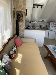 a living room with a couch and a kitchen at Villa SARA in Postira