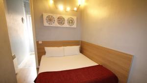 mały pokój z łóżkiem z czerwonym kocem w obiekcie Paraiso Hostel w Barcelonie