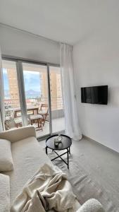 a white living room with a couch and a table at Nuevo apartamento 1 linea! in El Campello