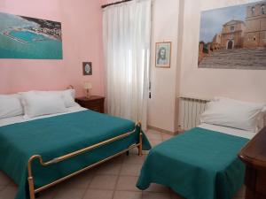 een slaapkamer met 2 bedden en groene lakens bij B&B Batarà - "La Terrazza del Centro" in Agrigento +118 foto's