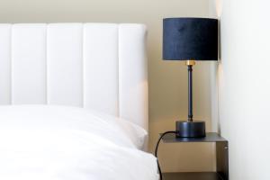 a black lamp sitting on a night stand next to a bed at The Rise - Premium Studio-HBF-Messe- Bürgerweide-CityGate-ÖVB Arena in Bremen