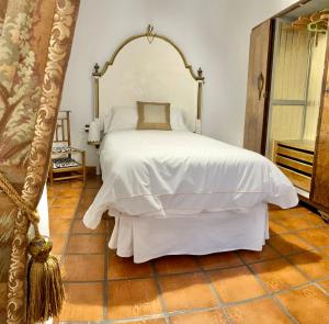 a bedroom with a white bed and a tiled floor at Las 9 Candelas alojamiento en el centro de Yecla in Yecla