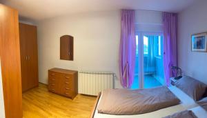 una camera con due letti e un comò con tende viola di Sunset Apartment a Umag (Umago)