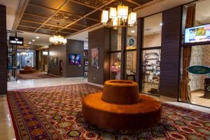 a large lobby with a large wooden ottoman on a rug at Marxal Resort & Spa in Sheki