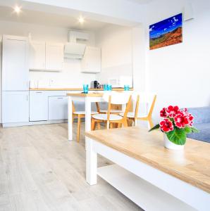 a kitchen and dining room with a table and chairs at Apartament Rodzinny in Lesko