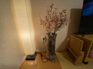 a vase filled with pink flowers in a room at Hotel EL Shinjuku 6 in Tokyo