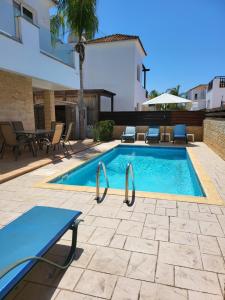 a swimming pool with a table and chairs next to a building at Villa Joia in Ayia Napa