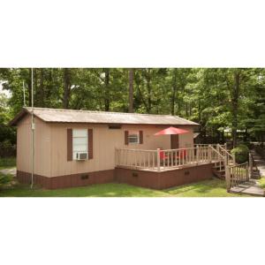 a small house with a porch and a deck at Sunburst RV Resort in Whitfield