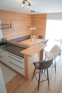 a kitchen with a counter and a table and chairs at Planaiblick-Lodge Schladming in Schladming