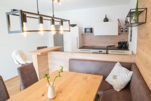 a dining room with a table and a kitchen at Planaiblick-Lodge Schladming in Schladming