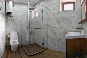 y baño con ducha, aseo y lavamanos. en Happy Flower Guesthouse en Verkhnyaya Alaarcha