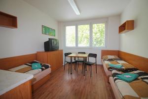 オストラヴァにあるHotelový dům Areálのベッド2台、テーブル、椅子が備わる客室です。