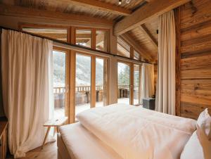 a bedroom with a bed and a large window at Gletscher-Chalet Stubai in Neustift im Stubaital