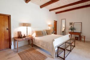 um quarto com uma cama branca e uma mesa em Langhuis Guesthouse em Graaff-Reinet