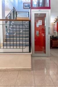 プラーイア・ア・マーレにあるHotel Rexの赤いドアと階段のある建物の入口