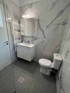 a bathroom with a toilet and a sink at Karma - Modern Apartment in Kanálion