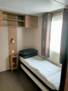 En eller flere senge i et værelse på Mobil Home 8P Domaine de Dugny