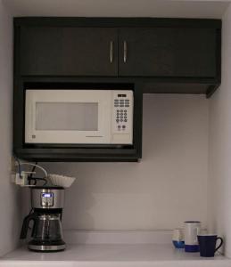 a microwave above a kitchen counter with a coffee maker at Hermoso depa cerca de consulado in Ciudad Juárez