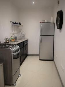 a kitchen with a stove and a refrigerator at Hermoso depa cerca de consulado in Ciudad Juárez