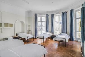 um quarto de hospital com quatro camas e janelas em Holland House (Victoria) em Londres