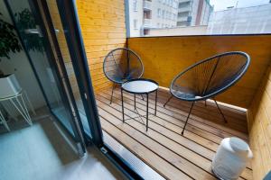 zwei Stühle auf einer Terrasse mit Fenster in der Unterkunft 3h,k,p - Keskellä Tamperetta kaunis parvekkeellinen uusittu kolmio in Tampere
