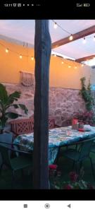 a table with a table cloth and a tree at Casa rural El olivo in Puigmoreno