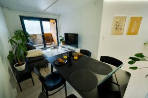 ein Wohnzimmer mit einem schwarzen Tisch und Stühlen in der Unterkunft 3h,k,p - Keskellä Tamperetta kaunis parvekkeellinen uusittu kolmio in Tampere