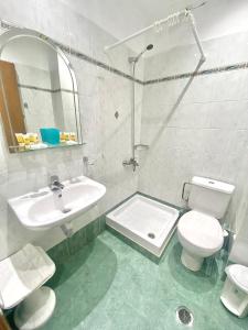 a bathroom with a sink and a toilet and a mirror at Nafplia Hotel in Nafplio