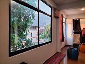 una camera con una grande finestra con vista sulla città di Sonu Guesthouse & Hostel a Rishikesh