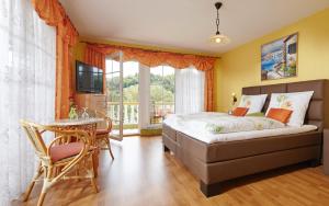 1 dormitorio con cama, mesa y TV en Panorama Hotel & Restaurant en Kröv