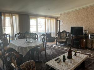 salon ze stołem i telewizorem w obiekcie White House w Kutaisi